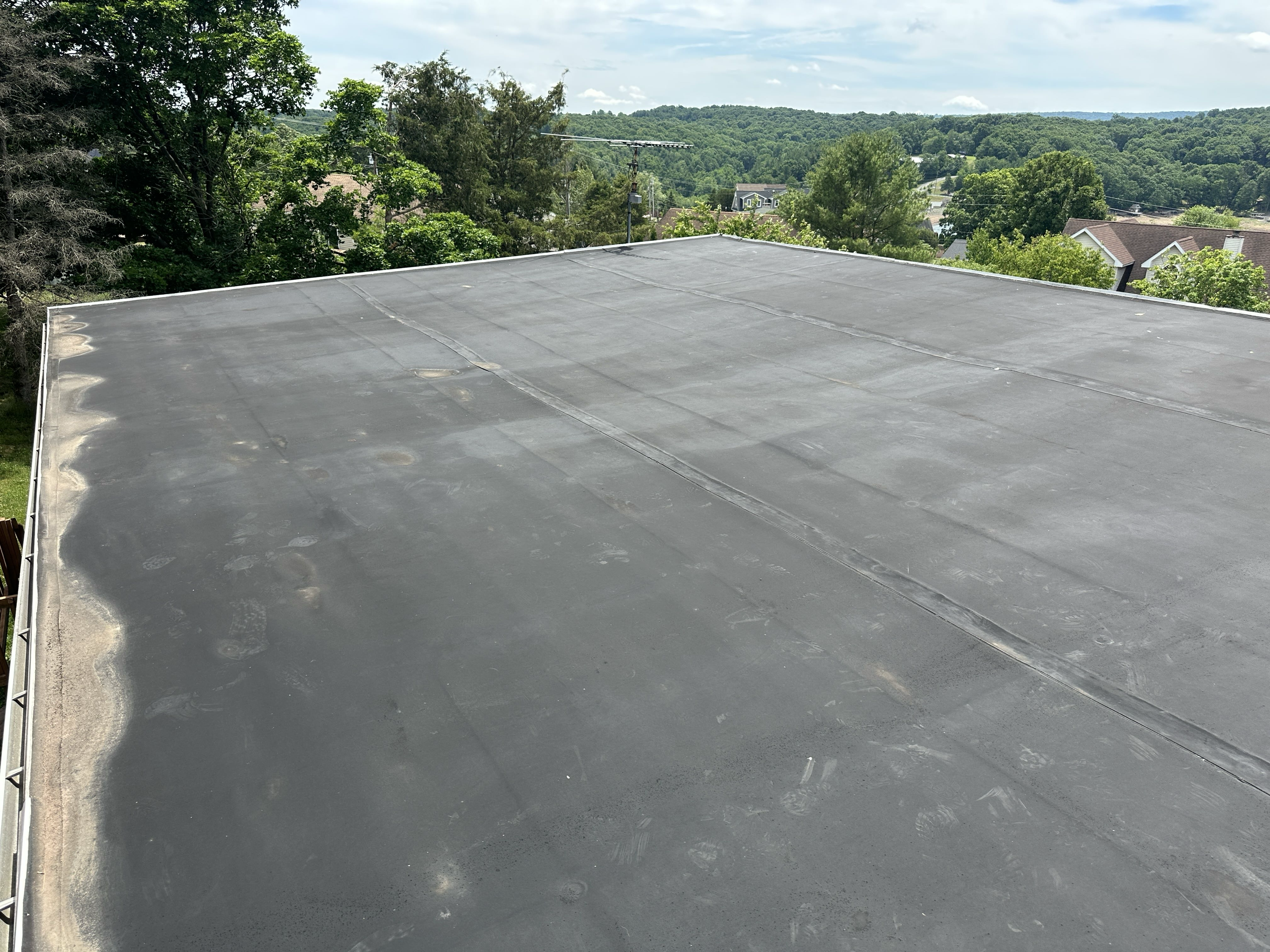 Aged, weathered EPDM flat roof before silicone restoration