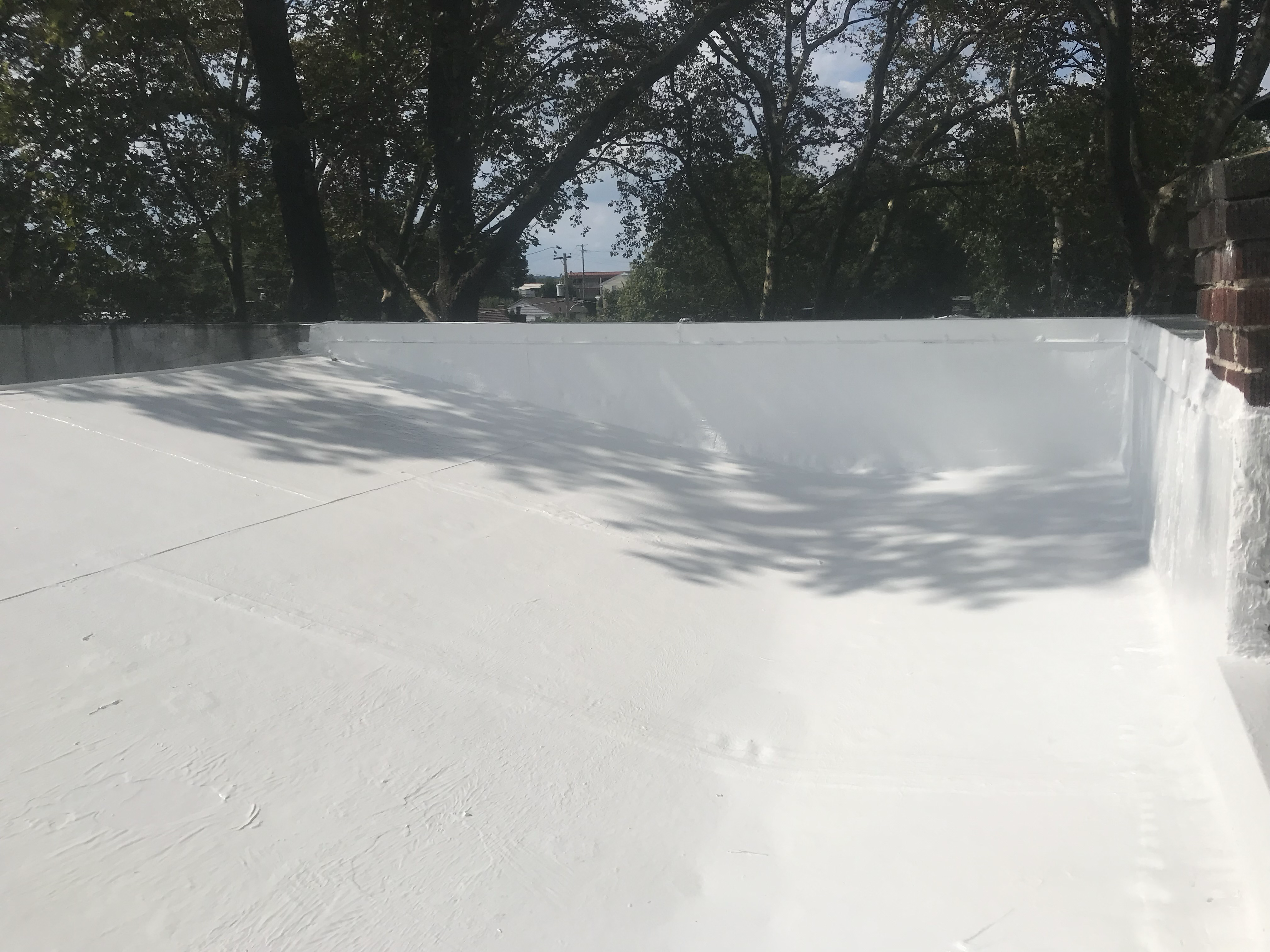 Brilliant white silicone roof coating finished on a flat residential roof in Chester County, PA