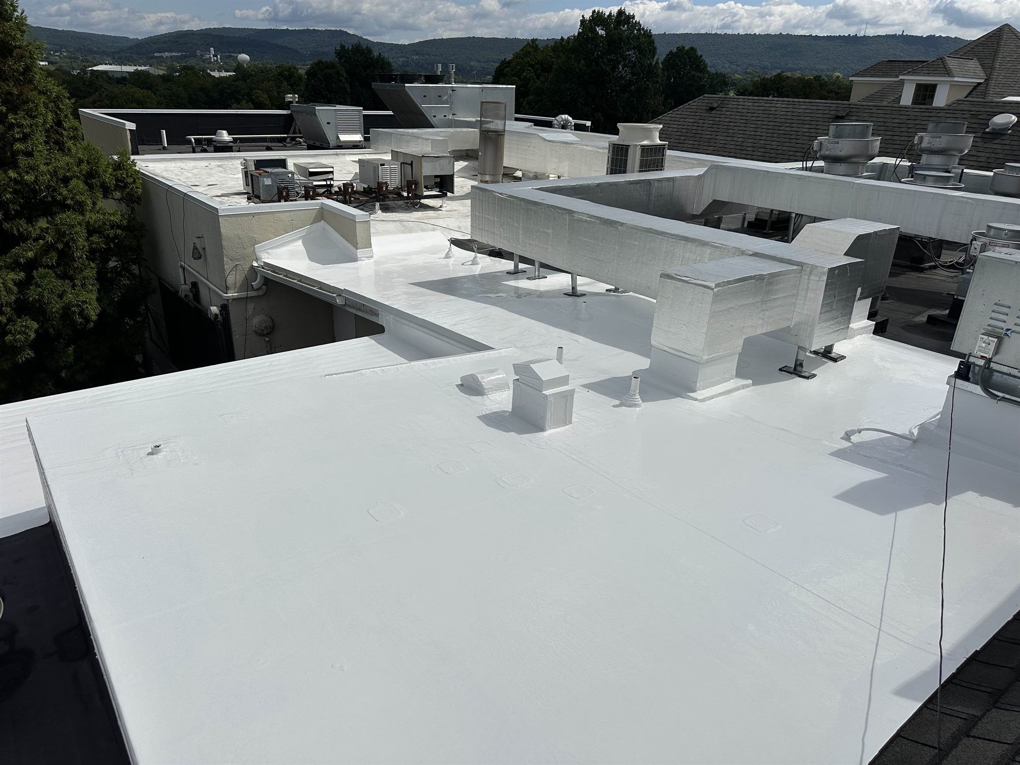 Finished white silicone commercial flat roof with a mountain view
