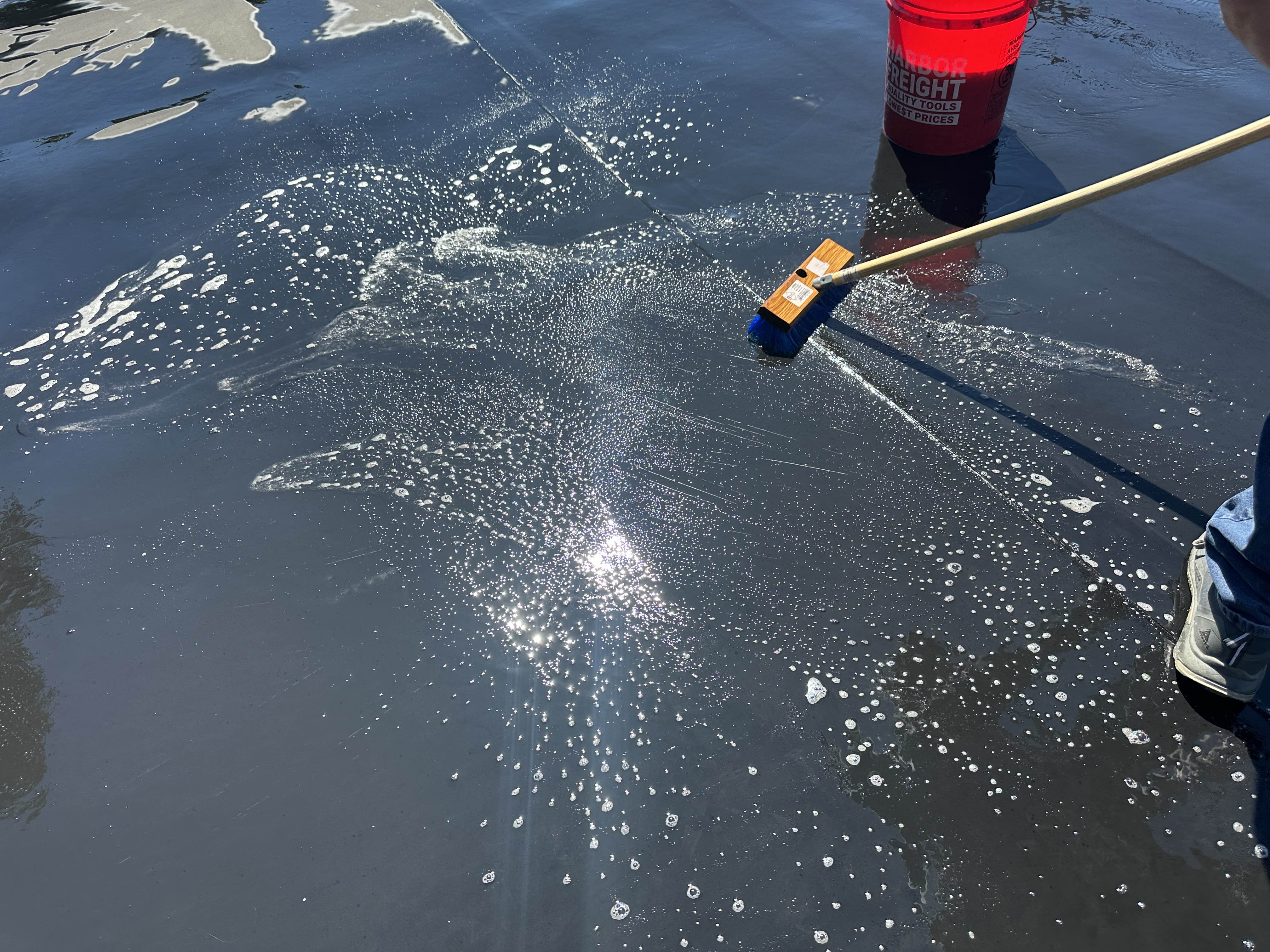 Scrubbing a flat roof membrane clean before silicone is applied