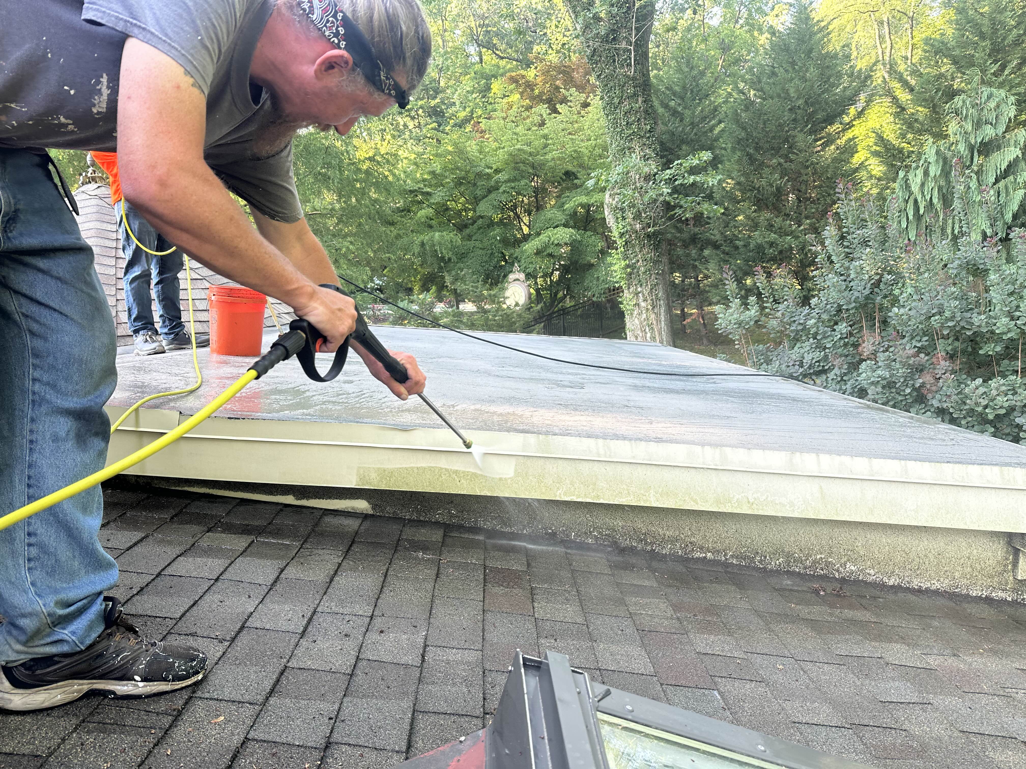 Power washing the edge and flashing of a flat roof