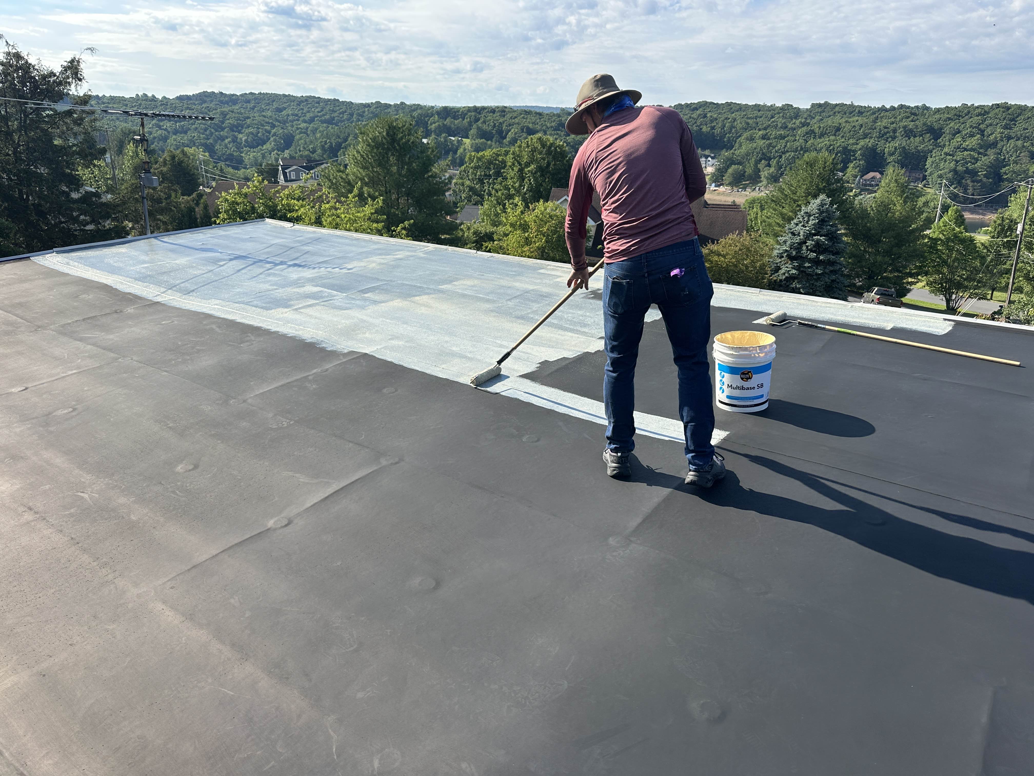 Rolling the base coat onto a prepped flat roof