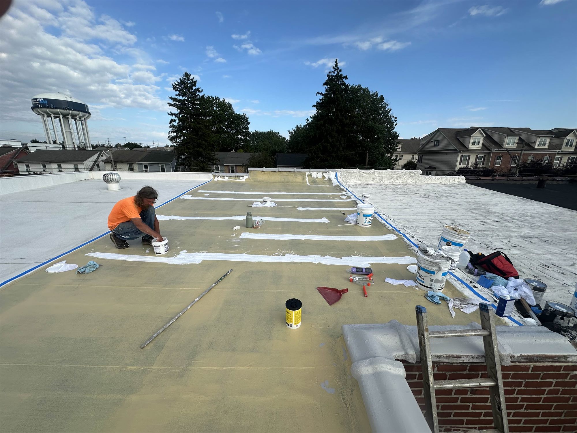 Roofer reinforcing flat roof seams with fabric and Liqui-Flash during maintenance