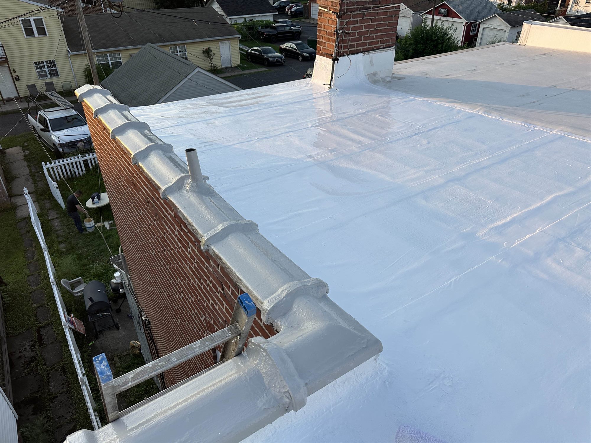 White silicone coating finished on a brick rowhome flat roof