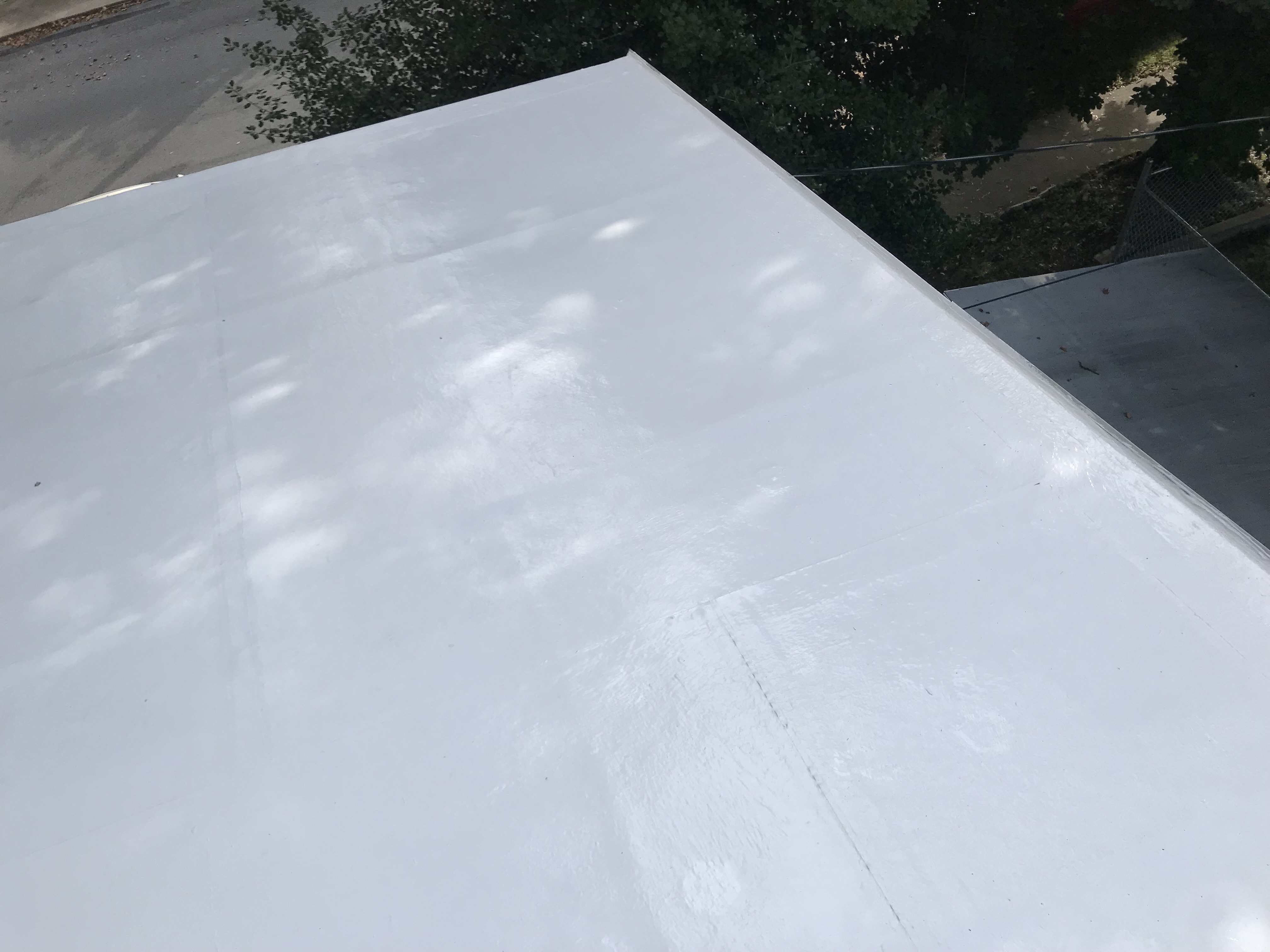 Silicone coating partially applied across a flat roof